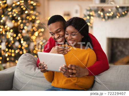 Family happy millennial african american husband and wife look at tablet and congratulate friends 72229407