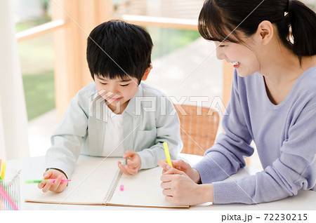 子供に字の書き方を教える母親の写真素材