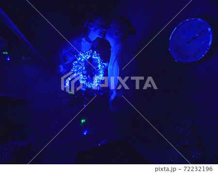 The family fast and fanny decorates the Christmas tree. Top view. Time on the clock is 23.45 on wall. Happy dad, mom, daughter are run around tree. 72232196