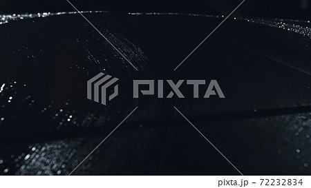 Drop flow down the hood. Close up view of bonnet car. Dark black cinematic picture. Process stage of polishing and washing auto. Hose is poured water. 72232834