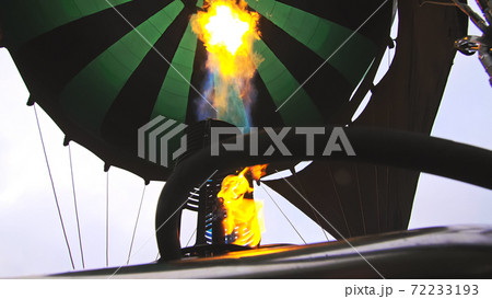 Adventure on hot air balloon watermelon. Burner directing flame into envelope. The aircraft fly in morning blue sky due to hot air. 72233193