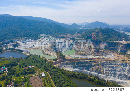Aerial view of machine excavator trucks dig coal mining or ore with black grunge ground in quarry with mountain hills. Nature landscape background in factory industry. Environment resources 72233874