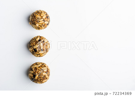 Diet vegetarian energy balls with nuts, chia, sunflower, dried fruit, oats, cocoa, peanut butter and honey. White background. Diet vegetarian energy balls with nuts, chia, sunflower, dried fruit, oats, cocoa, peanut butter and honey. White background. 72234369