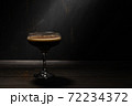 Jelly coffee with milk in a glass bowl sprinkled with chocolate chips. Rustic with deep shadows. 72234372