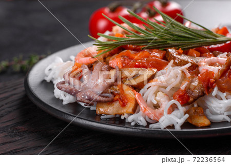 Tasty rice noodles with tomato, red pepper, mushrooms and seafood Tasty rice noodles with tomato, red pepper, mushrooms and seafood 72236564