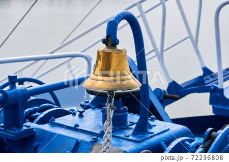 brass bell on the foredeck of a ship in cloudy light 72236808