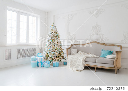 Stylish Christmas interior with an elegant sofa. Comfort home. Presents gifts underneath the tree in living room 72240876