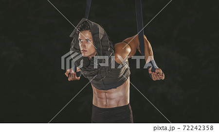 Beautiful young acrobat makes pull-ups on ropes 72242358