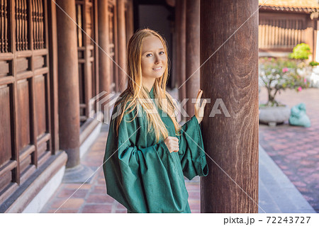 Woman tourist in national vietnamese dress in Temple of Literature in Hanoi in Southeast Asia, Vietnam. Vietnam reopens after coronavirus quarantine COVID 19 Woman tourist in national vietnamese dress in Temple of Literature in Hanoi in Southeast Asia, Vietnam. Vietnam reopens after coronavirus quarantine COVID 19 72243727