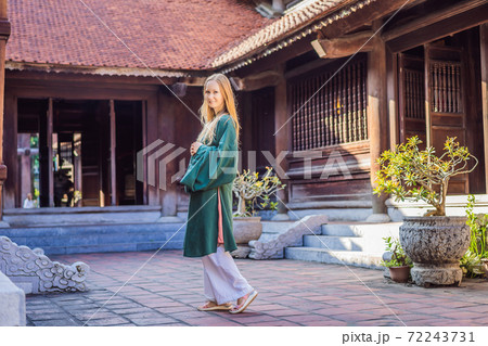 Woman tourist in national vietnamese dress in Temple of Literature in Hanoi in Southeast Asia, Vietnam. Vietnam reopens after coronavirus quarantine COVID 19 Woman tourist in national vietnamese dress in Temple of Literature in Hanoi in Southeast Asia, Vietnam. Vietnam reopens after coronavirus quarantine COVID 19 72243731