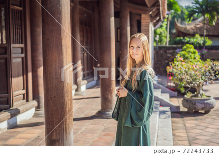 Woman tourist in national vietnamese dress in Temple of Literature in Hanoi in Southeast Asia, Vietnam. Vietnam reopens after coronavirus quarantine COVID 19 Woman tourist in national vietnamese dress in Temple of Literature in Hanoi in Southeast Asia, Vietnam. Vietnam reopens after coronavirus quarantine COVID 19 72243733