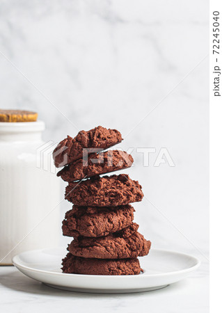 Stack of homemade chocolate cookies on a white saucer. Homemade baking concept. Stack of homemade chocolate cookies on a white saucer. Homemade baking concept. 72245040