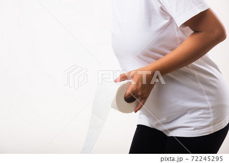 Woman diarrhea constipation holding tissue toilet paper roll on hand she crotch lower abdomen 72245295