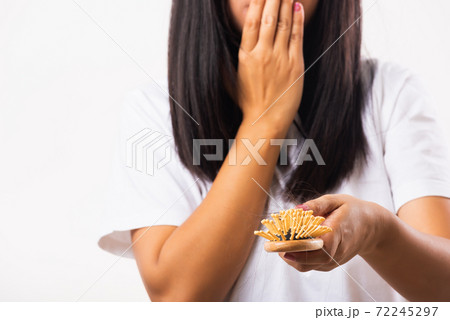 Woman weak hair problem her hold hairbrush with damaged long loss hair in the comb brush on hand 72245297