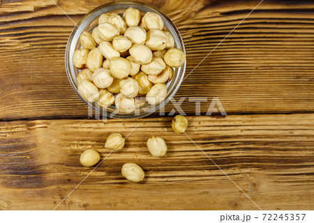 Peeled hazelnuts in glass bowl on wooden table. Top view Peeled hazelnuts in glass bowl on wooden table. Top view 72245357