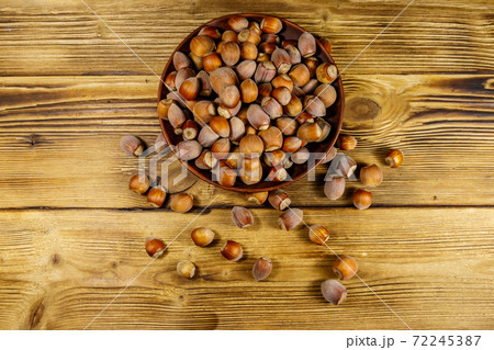 Hazelnuts in ceramic plate on a wooden table. Top view 72245387