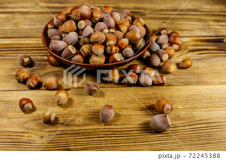 Hazelnuts in ceramic plate on a wooden table 72245388