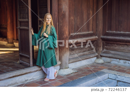 Woman tourist in national vietnamese dress in Temple of Literature in Hanoi in Southeast Asia, Vietnam. Vietnam reopens after coronavirus quarantine COVID 19 Woman tourist in national vietnamese dress in Temple of Literature in Hanoi in Southeast Asia, Vietnam. Vietnam reopens after coronavirus quarantine COVID 19 72246137