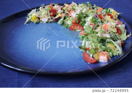 Fresh vegetable salad on a plate on a blue background Fresh vegetable salad on a plate on a blue background 72248995