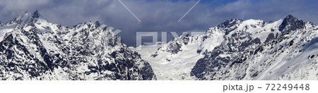 Panorama of snowy mountains with glacier in storm clouds at winter Panorama of snowy mountains with glacier in storm clouds at winter 72249448