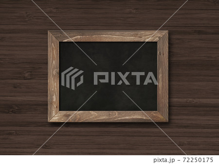 Old rustic black board isolated on a dark wooden background 72250175