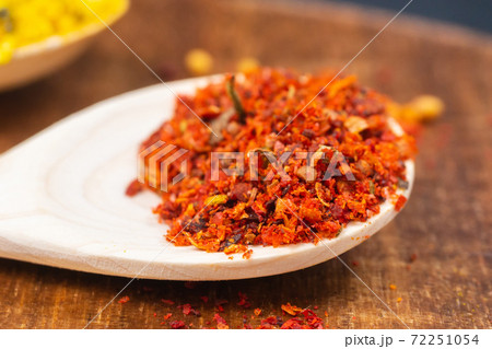 dry spices in a wooden spoon close-up on a vintage background. selective focus 72251054
