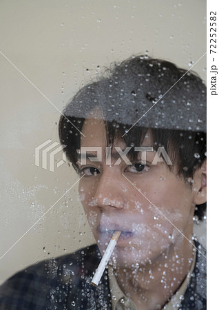 wet cigarette man Portrait of a man smoking a cigarette by the... - Stock Photo [72252582]