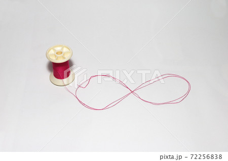 Pink thread from the thread reel put the symbol is Infinity on white background. Pink thread from the thread reel put the symbol is Infinity on white background. 72256838