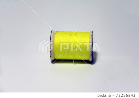 Dirty yellow thread in the thread roll on white background. Dirty yellow thread in the thread roll on white background. 72256843