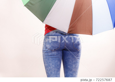 Woman standing under multicolored umbrella Woman standing under multicolored umbrella 72257687