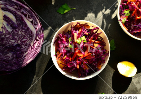 Red cabbage salad with bell peppers and carrots. Dark background. Healthy bright food. Top view Red cabbage salad with bell peppers and carrots. Dark background. Healthy bright food. Top view 72259968
