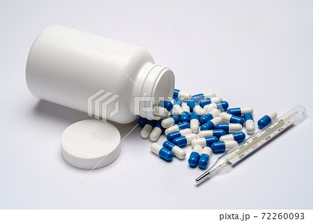 Medications capsules in a bottle and thermometer on light grey background 72260093