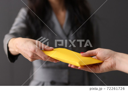 Womans hand giving envelope to another woman concept 72261726