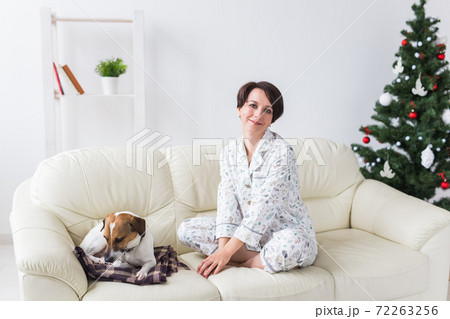 Happy young woman wearing pajama in living room with christmas tree. Holidays concept. 72263256