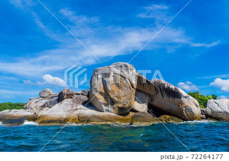 Seascape of rocky island on deep blue sea sunshine day Seascape of rocky island on deep blue sea sunshine day 72264177