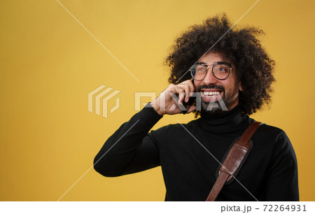 Portrait of mature man with smartphone in a studio on yellow background. Portrait of mature man with smartphone in a studio on yellow background. 72264931
