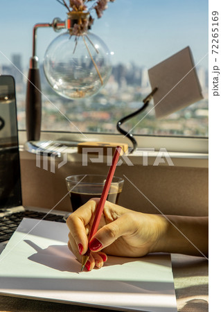 Hand of business woman writing on paper at her workstation. 72265169