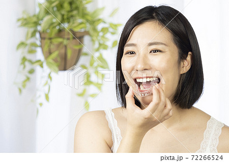 両手でマウスピースを持つ女性 72266524