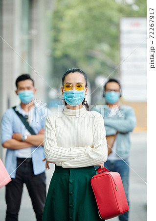 Serious young Asian woman in mask 72267917