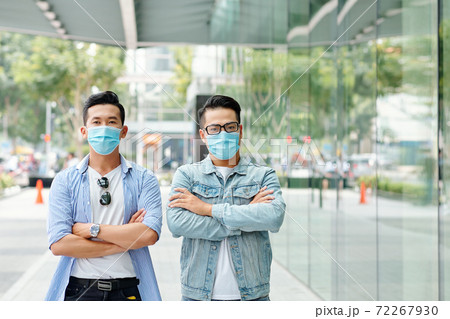 Men in masks standing in the street 72267930