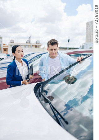 Looking at automobiles in car dealership 72268019