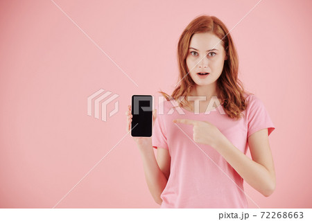 Woman pointing at smartphone Woman pointing at smartphone 72268663