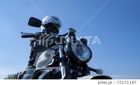 バイクライフ スマホを操作する中年ライダーとミドルクルーザー 千葉県の写真素材