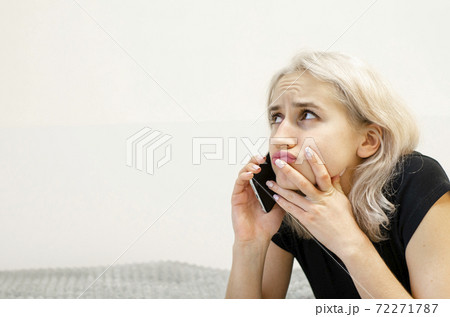 A young girl with blond hair communicates on the phone. A young girl with blond hair communicates on the phone. 72271787