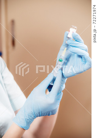 Woman doctor beautician picks up liquid into a syringe for injection rejuvenation 72271974
