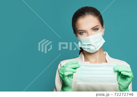 Portrait of doctor with protective medical face mask on blue background. Medicine concept Portrait of doctor with protective medical face mask on blue background. Medicine concept 72272746