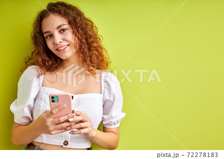 young and beautiful caucasian girl chatting with friend on smartphone young and beautiful caucasian girl chatting with friend on smartphone 72278183