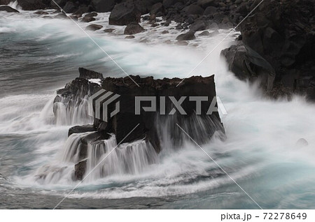 伊豆の城ヶ崎海岸の岩礁に打ち付ける荒波と波しぶきの写真素材
