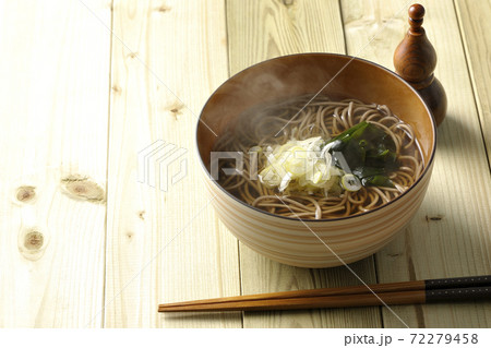 刻み葱とわかめがトッピングされたシンプルな掛け蕎麦と瓢箪型の七味入れ 72279458