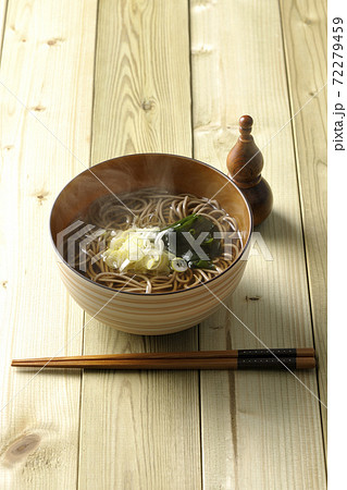 刻み葱とわかめがトッピングされたシンプルな掛け蕎麦と瓢箪型の七味入れ 72279459